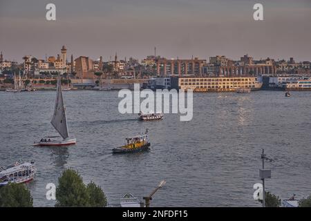 Luxor, Egitto tramonto girato dalla riva ovest mostrando il fiume Nilo con Felucche, navi da crociera e Luxor Tempio in riva est Foto Stock