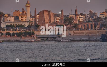 Luxor, Egitto tramonto girato dalla riva ovest mostrando il fiume Nilo con Felucche, navi da crociera e Luxor Tempio in riva est Foto Stock