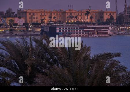 Luxor, Egitto tramonto girato dalla riva ovest mostrando il fiume Nilo con navi da crociera, Felucche e Winter Palace hotel in riva est Foto Stock