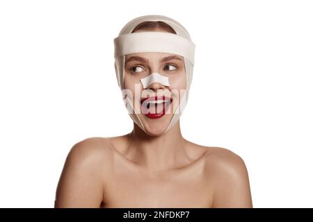 Naso femminile dopo chirurgia estetica. Giovane bella donna. Chirurgia plastica o sollevamento viso per le giovani donne. Testa del paziente isolata in studio bianco Foto Stock