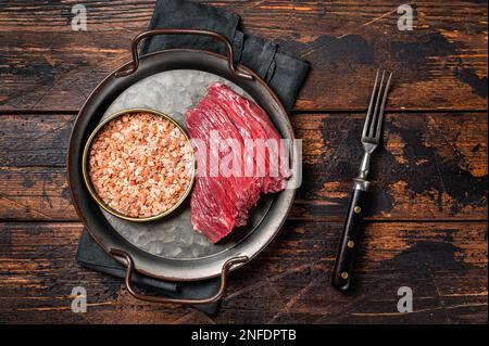 Carne di selvaggina cruda di cervo cara, bistecca di carne. Sfondo di legno. Vista dall'alto. Foto Stock