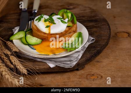 Uovo in camicia per colazione. Pane fritto e avocado. Il tuorlo proviene dalla proteina. Cibo appetitoso. Taglio perfetto di uova in camicia con toast all'avocado. Foto Stock