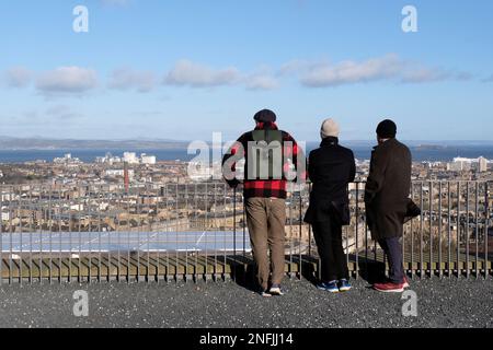 Edimburgo, Scozia, Regno Unito. 17th febbraio 2023. I visitatori della collina di Calton si sono avvolti contro i freddi venti. Ammirando la vista sui tetti della città che si affaccia a nord sul quarto estuario verso Fife. Credit: Craig Brown/Alamy Live News Foto Stock