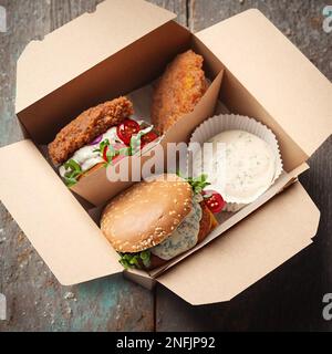 Cibo di strada. Hamburger con polpette in scatole di carta. consegna di cibo. Foto Stock
