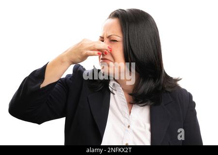 Primo piano di una donna d'affari adulta in formalwear tenere il naso come cattivo odore puzzolente concetto con espressione grossed isolato su sfondo bianco Foto Stock