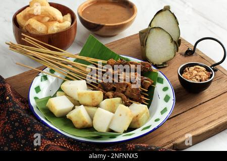 Sate Padang. Satay di manzo piccante di Padang, West Sumatra. Servito con salsa di curry piccante e Longong o Ketupat. Servito su piastra di smalto Foto Stock