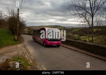 Un servizio di autobus rurale su Brow Lane nella valle di Shibden vicino a Halifax, West Yorkshire, Regno Unito negozia la stretta corsia di campagna sul lato della collina di Pennine. Credit: Windmill Images/Alamy Live News Foto Stock