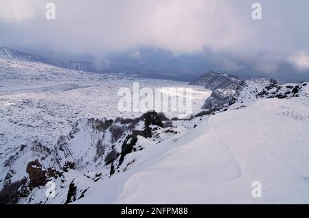 Paesaggio invernale della Valle del Bove innevata e crinale montano della 'Schiena dell'Asino' e della 'Serra del Salipizio' nell'Etna National Pa Foto Stock