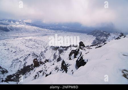 Paesaggio invernale della Valle del Bove innevata e crinale montano della 'Schiena dell'Asino' e della 'Serra del Salipizio' nell'Etna National Pa Foto Stock