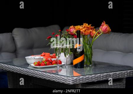 Cena romantica al tavolo con champagne, fragole e fiori. natura morta con le rose Foto Stock