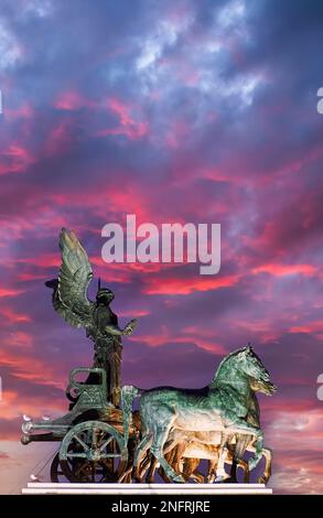 La Quadriga dell'unità sulla cima di uno dei due propylaea al Monumento Nazionale Vittorio Emanuele II (Vittoriano) al tramonto. Roma Italia Foto Stock