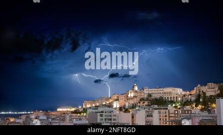 Cagliari panorama di notte con lampi dietro la città. Temporale sul cielo notturno, sopra la città. Foto Stock