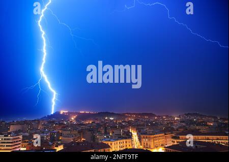 Fulmini in prossimità della città di Cagliari. Cagliari vista di notte con fulmini. Foto Stock