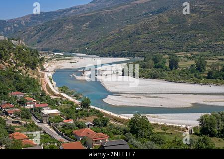 Villaggio e ponte sul fiume Drinos / Drinos, affluente del Vjosë che attraversa la valle boschiva, Lumi Drino nel sud dell'Albania Foto Stock