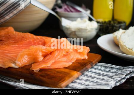 Lox appena tagliato su un tagliere di legno: Vista in primo piano di fette di salmone salato su un tagliere di legno Foto Stock