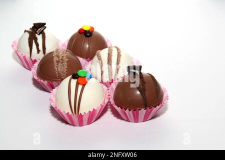 Set di bombe al cioccolato, ripieno di marshmallow e cioccolato bianco su sfondo bianco Foto Stock