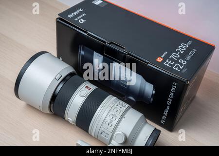 Nuovo obiettivo e scatola G-Master Sony FE 70-200mm F2,8 GM OSS II. Disimballaggio dalla confezione. Focalizzazione selettiva, isolata su Whi Foto Stock