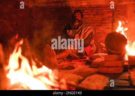 Kathmandu, Nepal. 17th Feb, 2023. Un uomo sacro indù, o Sadhu, il seguace di Lord Shiva, esegue rituali alla vigilia del festival Maha Shivaratri presso i locali del tempio di Pashupatinath a Kathmandu. I devoti indù del Nepal e dell'India vengono in questo tempio per partecipare al festival Shivaratri, uno dei più grandi festival indù dedicato a Lord Shiva e celebrato da devoti di tutto il mondo. Credit: SOPA Images Limited/Alamy Live News Foto Stock