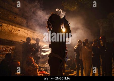 Kathmandu, Nepal. 17th Feb, 2023. Un uomo sacro indù, o Sadhu, il seguace di Lord Shiva, fuma marijuana alla vigilia del festival Maha Shivaratri presso i locali del tempio Pashupatinath a Kathmandu. I devoti indù del Nepal e dell'India vengono in questo tempio per partecipare al festival Shivaratri, uno dei più grandi festival indù dedicato a Lord Shiva e celebrato da devoti di tutto il mondo. Credit: SOPA Images Limited/Alamy Live News Foto Stock