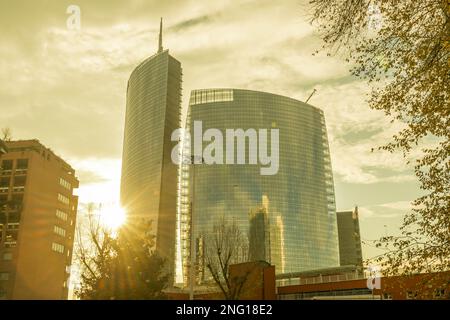 Moderno grattacielo e alberi con Sunbeam a Milano, Lombardia in Italia. Foto Stock