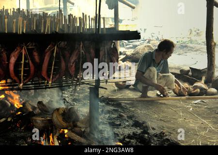 Un luogo di lavoro domestico in cui vengono prodotte carni di tonno con skipjack affumicato, comunemente note come 'cakalang fufu' a Bitung, nel Nord Sulawesi, Indonesia. Secondo la FAO nel loro ultimo rapporto (2022), l'Indonesia è il terzo produttore mondiale di animali acquatici per la pesca e l'acquacoltura. Cinque paesi (Cina, India, Indonesia, Vietnam e Perù) sono responsabili di circa il 58% della produzione mondiale. Secondo la relazione, l'Indonesia è anche uno dei paesi in cui gli alimenti acquatici contribuiscono per la metà o più all'assunzione totale di proteine animali. Foto Stock