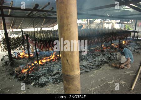 Un luogo di lavoro domestico in cui vengono prodotte carni di tonno con skipjack affumicato, comunemente note come 'cakalang fufu' a Bitung, nel Nord Sulawesi, Indonesia. Secondo la FAO nel loro ultimo rapporto (2022), l'Indonesia è il terzo produttore mondiale di animali acquatici per la pesca e l'acquacoltura. Cinque paesi (Cina, India, Indonesia, Vietnam e Perù) sono responsabili di circa il 58% della produzione mondiale. Secondo la relazione, l'Indonesia è anche uno dei paesi in cui gli alimenti acquatici contribuiscono per la metà o più all'assunzione totale di proteine animali. Foto Stock