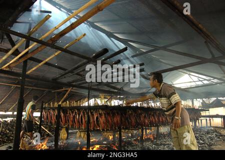 Un luogo di lavoro domestico in cui le carni di tonni dello skipjack affumicato sono prodotte a Bitung, Sulawesi del Nord, Indonesia. Secondo la FAO nel loro ultimo rapporto (2022), l'Indonesia è il terzo produttore mondiale di animali acquatici per la pesca e l'acquacoltura. Cinque paesi (Cina, India, Indonesia, Vietnam e Perù) sono responsabili di circa il 58% della produzione mondiale. Secondo la relazione, l'Indonesia è anche uno dei paesi in cui gli alimenti acquatici contribuiscono per la metà o più all'assunzione totale di proteine animali. Foto Stock