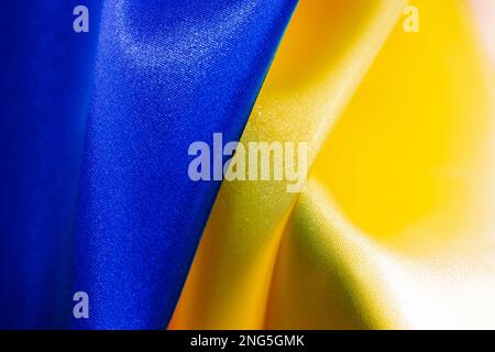 Tessuto curvato bandiera di Ucraina. Blu giallo ucraino bandiera astratto sfondo carta da parati. Ondulazione della bandiera di seta nazionale texture. Tessuto raso tessuto fragm Foto Stock