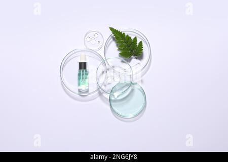 Prodotto cosmetico organico, ingrediente naturale e vetreria da laboratorio su sfondo bianco, vista dall'alto Foto Stock