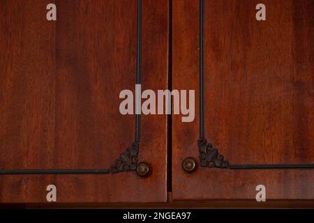 Porte marroni con maniglie di un vecchio armadio sovietico laccato primo piano Foto Stock