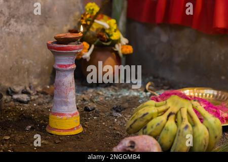 Lampada in argilla su stand pilsuj bruciante con fiamma gialla illuminata per rituali indù Pooja come durga puja, saraswati, diwali holi ecc. Foto Stock