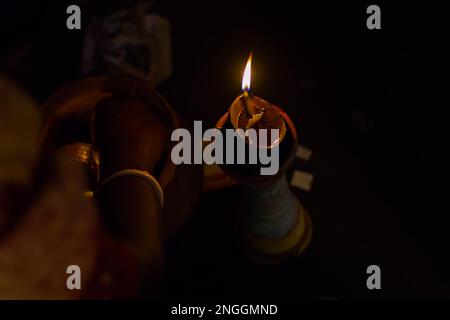 Lampada in argilla su stand pilsuj bruciante con fiamma gialla illuminata per rituali indù Pooja come durga puja, saraswati, diwali holi ecc. Foto Stock