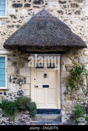 Una porta pittoresca nel villaggio di pescatori di Beer a Devon, Inghilterra. Il portico di paglia segna l'ingresso al Captains Cottage. Foto Stock