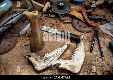 Srinagar, India. 18th Feb, 2023. Le ossa di scarto dagli animali sono viste stendersi su un tavolo da lavoro ad un laboratorio a Srinagar. Ventenne Aziz-ur-Rehman di Srinagar artigianato gioielli da ossa animali. L'arte chiamata bone crafting è unica per il Kashmir come il fuoco è stato sempre sul ricamo, tessitura e tessitura del tappeto. Rehman è ossessionato con fare la ricchezza dalle ossa di scarto e dal legno. Credit: SOPA Images Limited/Alamy Live News Foto Stock