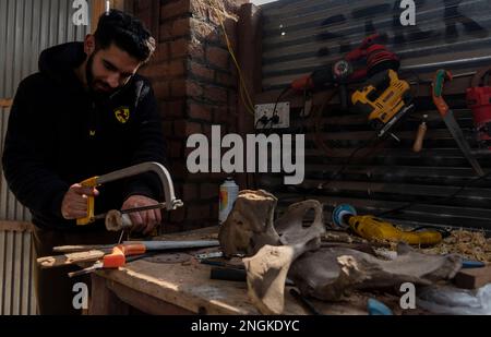 Srinagar, India. 18th Feb, 2023. Aziz-ul-Rehman si vede lavorare su un osso di mucca nel suo laboratorio a Srinagar. Ventenne Aziz-ur-Rehman di Srinagar artigianato gioielli da ossa animali. L'arte chiamata bone crafting è unica per il Kashmir come il fuoco è stato sempre sul ricamo, tessitura e tessitura del tappeto. Rehman è ossessionato con fare la ricchezza dalle ossa di scarto e dal legno. Credit: SOPA Images Limited/Alamy Live News Foto Stock