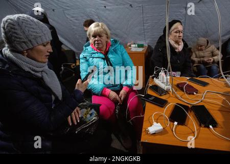 Kiev, Ucraina. 17th Dec, 2022. Le persone caricano i loro dispositivi da un generatore di energia elettrica in un punto di riscaldamento, organizzato dal servizio di emergenza statale, durante un'interruzione di corrente a Kiev. La Russia continua ad attaccare l'infrastruttura critica dell'Ucraina per lasciare gli ucraini senza elettricità e riscaldamento durante i freddi mesi invernali (Foto di Oleksii Chumachenko/SOPA Images/Sipa USA) Credit: Sipa USA/Alamy Live News Foto Stock