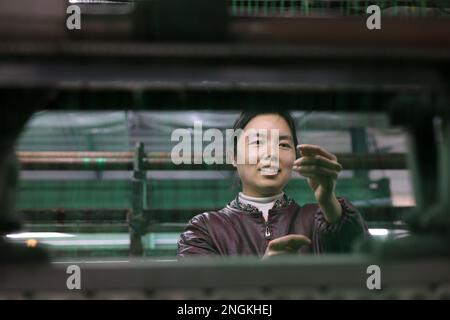 BINZHOU, CINA - 18 FEBBRAIO 2023 - Un lavoratore produce i prodotti della rete della corda ad un'officina di un'impresa della rete della corda nella città di Jianglou, contea di Huimin, Binzh Foto Stock