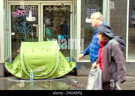 Glasgow, Scozia, Regno Unito 18th febbraio 2023. UK Weather: Bagnata come pioggia germogli ombrelloni sul centro della città. I senzatetto usano le tende pop up per le strade come ombrelli. Credit Gerard Ferry/Alamy Live News Foto Stock