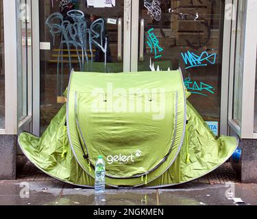 Glasgow, Scozia, Regno Unito 18th febbraio 2023. UK Weather: Bagnata come pioggia germogli ombrelloni sul centro della città. I senzatetto usano le tende pop up per le strade come ombrelli. Credit Gerard Ferry/Alamy Live News Foto Stock