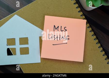 Concetto di MLS Listing scrivere su note appiccicose isolate su tavola di legno. Foto Stock