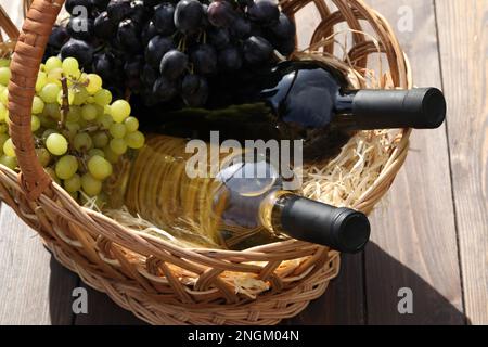 due bottiglie di vino rosso e bianco con uva Foto Stock