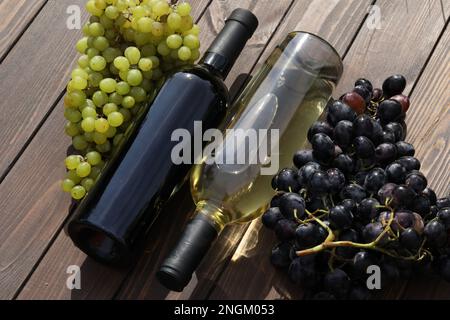 due bottiglie di vino rosso e bianco con uva Foto Stock