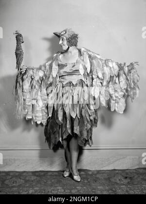 Donna in un costume di uccello comunes con l'uccello modello appollaiato sulla sua mano - la signora John F Gaynor Foto Stock