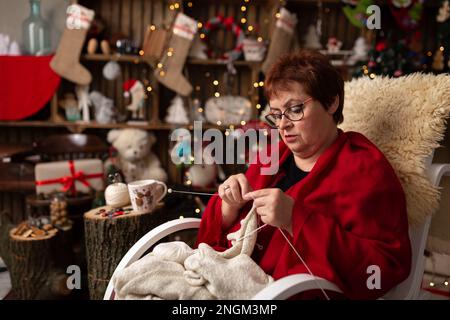 La nonna scaglia un gufo peluche nella disposizione di Natale. In studio Foto Stock