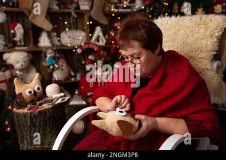 La nonna scaglia un gufo peluche nella disposizione di Natale. In studio Foto Stock