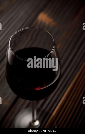Vino rosso in vetro su tavola di legno Foto Stock