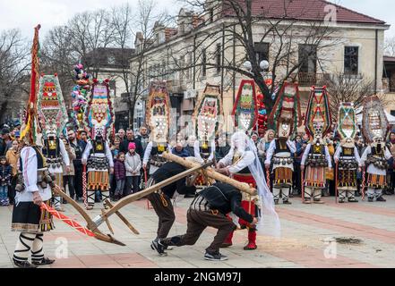 Elhovo Bulgaria Febuary 18 2023: Gruppi di cucina e il 'Djamalo' una usanza dal villaggio di Malomirovo. I rituali del Kuker simboleggiano il passaggio dell'inverno e l'arrivo della primavera. Oggi le squadre di tutta la regione hanno eseguito azioni rituali da parte dei kukers memebers come aratura, raccolta, semina, matrimonio per la salute e la fertilità. Mettendo maschere spaventose sulla loro testa, appesi clapper, campane e bastoni, il loro scopo è quello di scappare spiriti malvagi e forze impure Cliff Norton Alamy Live News Foto Stock