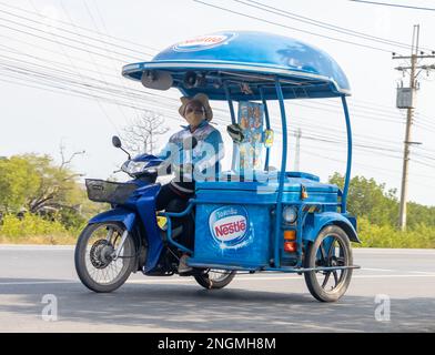 BANGKOK, THAILANDIA, 07 2023 FEBBRAIO, un fornitore di gelati guida una motocicletta a tre ruote lungo una strada Foto Stock