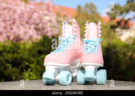 Eleganti pattini a rotelle rosa all'aperto nelle giornate di sole Foto Stock