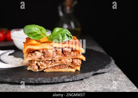 Deliziose lasagne cotte servite su un piatto di ardesia Foto Stock